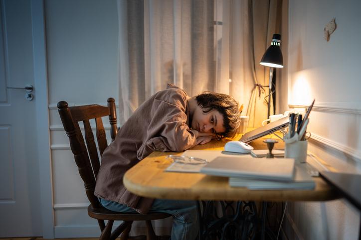 A struggling student works late at her desk