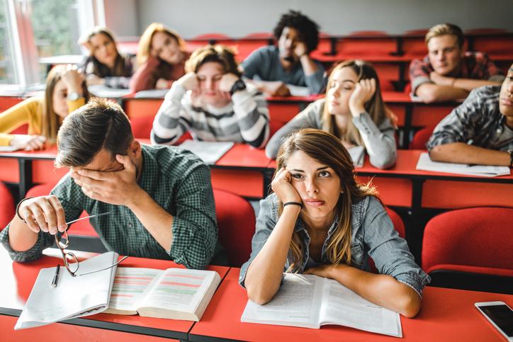 Bored students sit slumped in a lecture hall