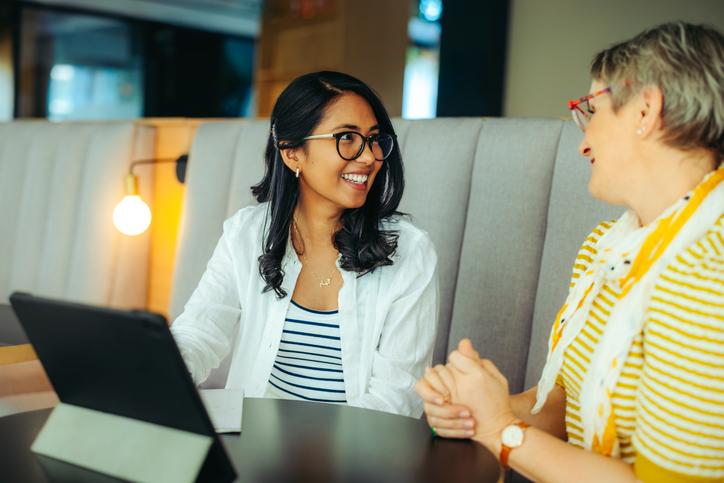 A supervisor and supervisee chat over a tablet