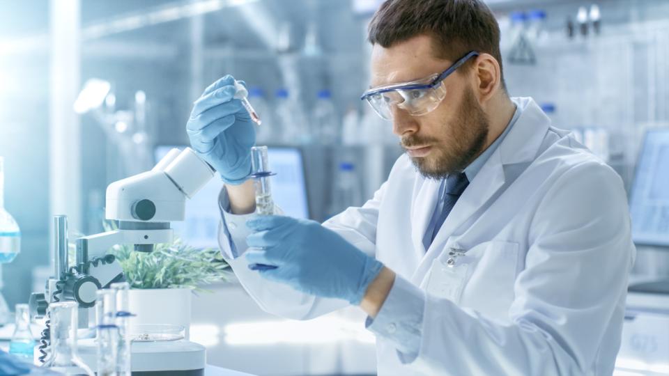 A scientist filling a test tube in a lab