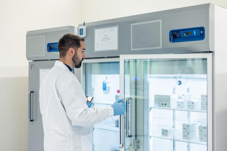 A scientist opens a freezer in a lab