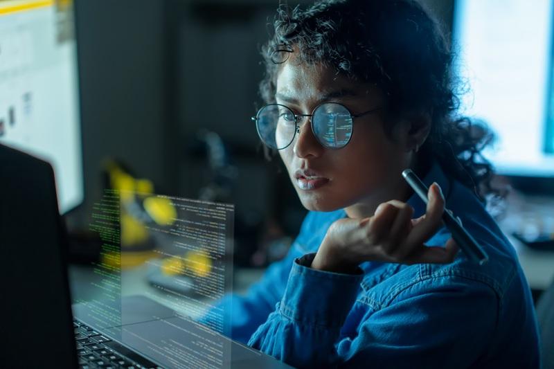 A programmer reviewing code on her desktop
