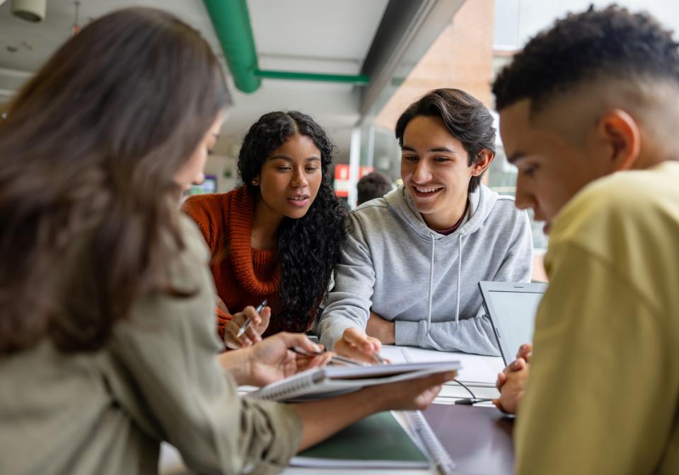 A group of students at a desk working on a project