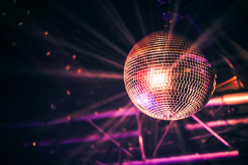 A disco ball suspended from the ceiling of a dimly lit room