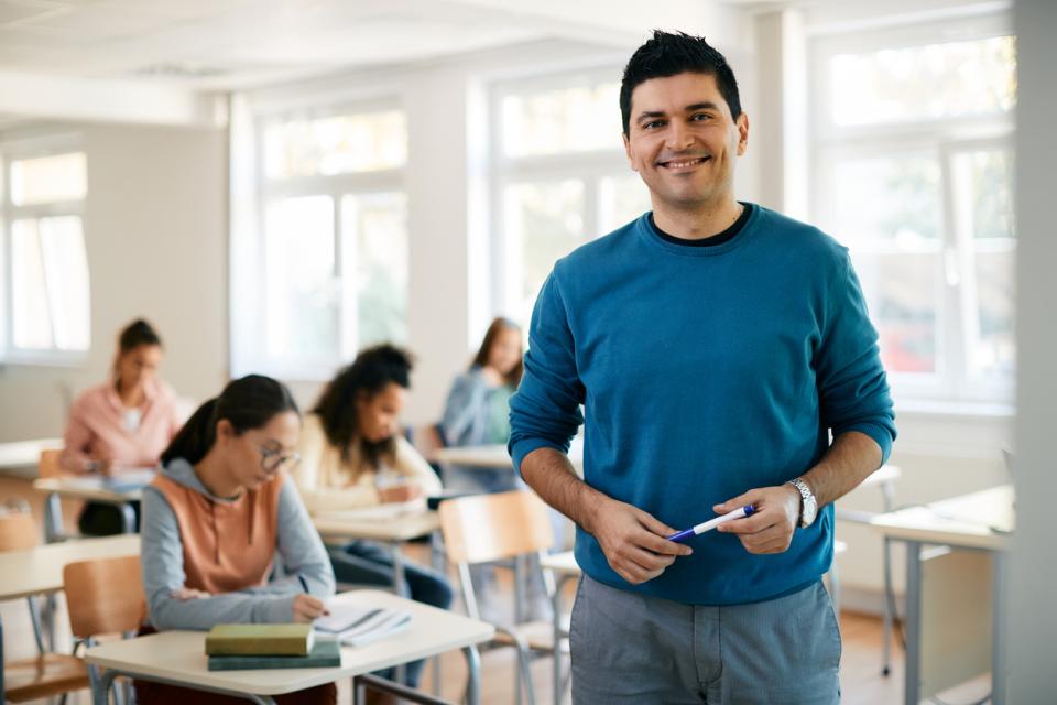 A professor in class smiling to camera