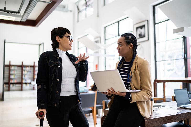 Transgender disabled woman talking to a researcher with a laptop