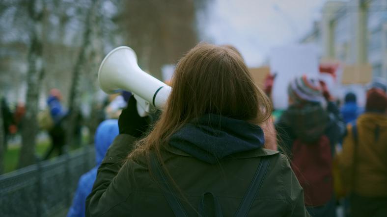 A young woman holds a megaphone at a protest