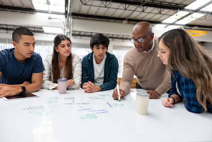 A professor guiding students through a task