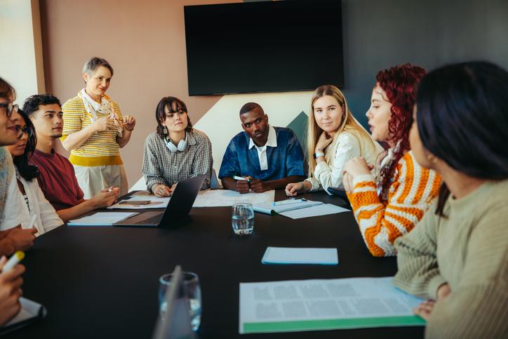 A group of university students sitting around a table having a discussion