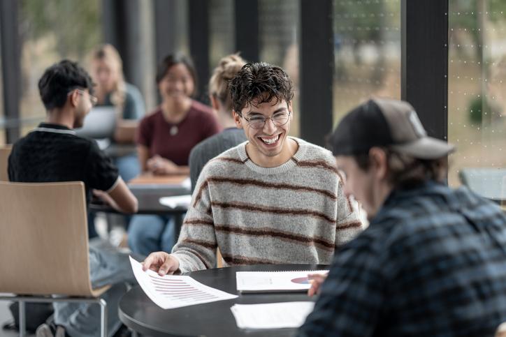 University students sitting at a table discussing a project