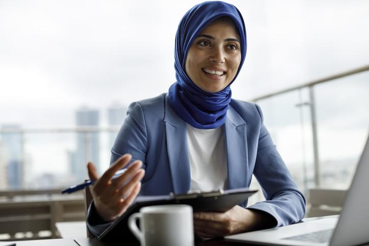A woman wearing a headscarf in an office