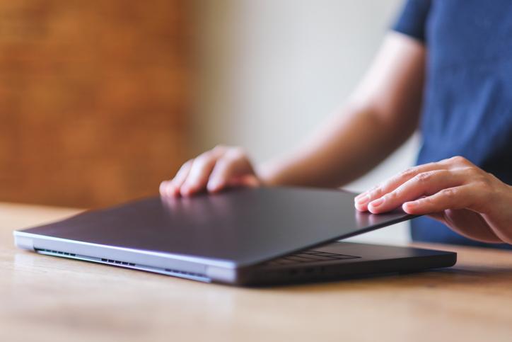 A close-up of a laptop being closed