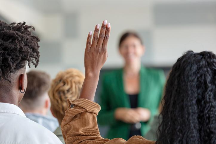A student raises a hand in the classroom