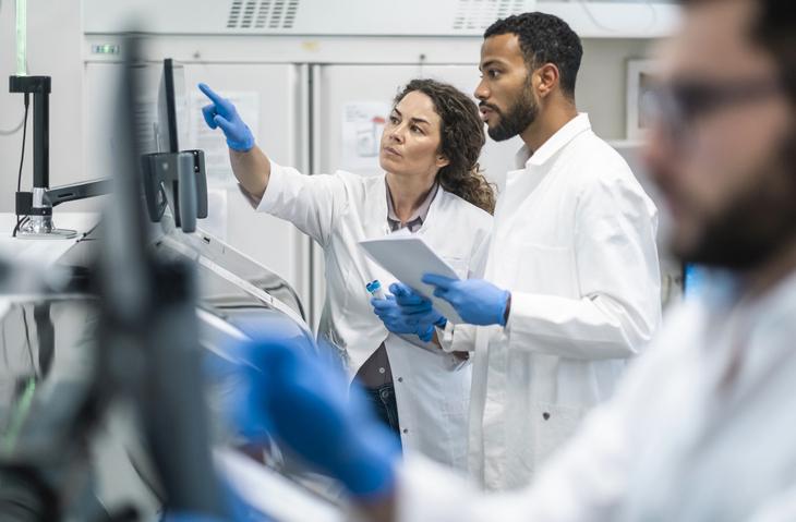 Two lab workers discussing something on a screen