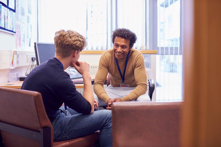 A counsellor offering advice to a student in an office