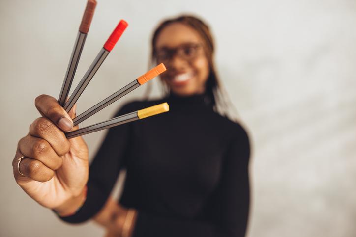 A student holding marker pens