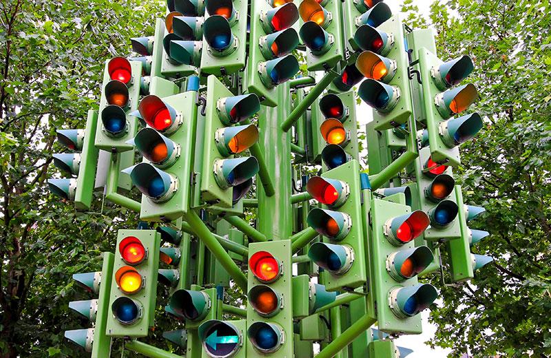 Lots of traffic lights mounted on single large pole