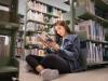 Female student reading a book in the university library