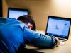 Depressed student hiding face on arms in front of laptop