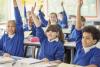 Primary school children with raised hands