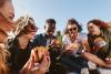 multiracial group of students eating burgers outside