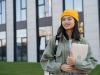 Young female Asian student holding laptop