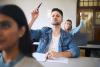 Students raising hands in class