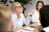 Female head of department speaking to her employees during a team meeting