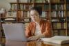 Asian academic at laptop in library