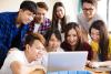 Chinese students crowding around a laptop in class