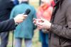 A journalist interviews a man in a raincoat