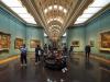 The interior of an art gallery with people walking around