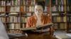 A woman researching at a desk in a library