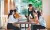 Students discuss their work round a table