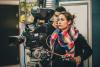 A young woman operates a camera