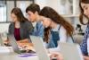 Students use their laptops in class, looking focused