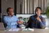 Two black men shaking hands and smiling