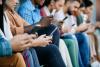 A row of people using smartphones