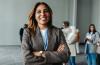 A woman in professional attire smiling to canera