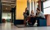 Educators chat on a sofa with a laptop