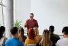A lecturer giving an engaging presentation in front of a class full of students
