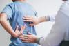 A physiotherapist inspects a patient's back