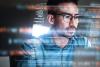 Asian man with glasses looking at screen