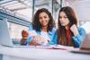 Two female students looking at a flash card