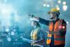 A male and female engineer in safety gear pointing at project