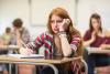 Red-headed female student looking unhappy in an exam