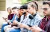A line of students look at their phones