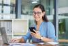 A woman smiles as she checks her phone