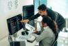 Two people looking at code on a computer screen