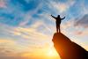 A figure stands on top of a mountain